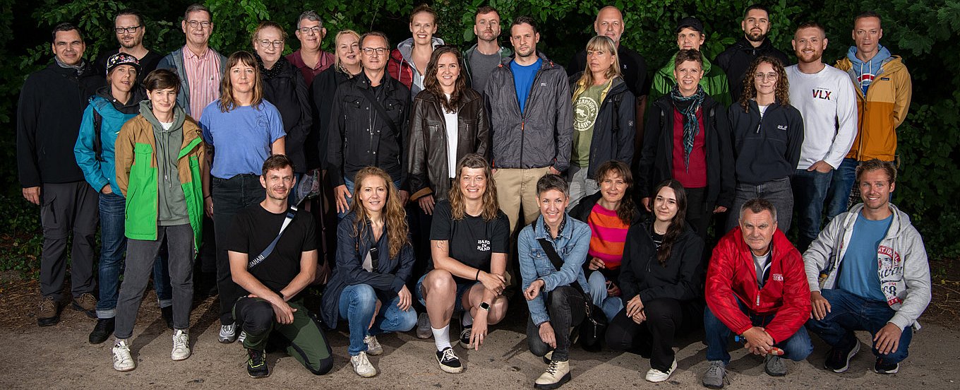 Teamfoto Velomax mit den MiarbeiterInnen vor grünem Hintergrund.