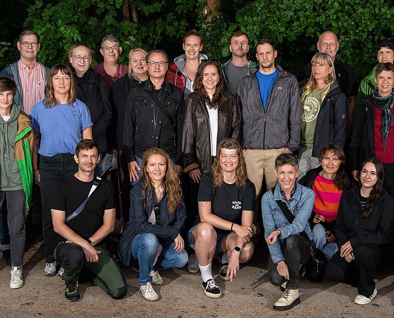 Teamfoto Velomax mit den MiarbeiterInnen vor grünem Hintergrund.